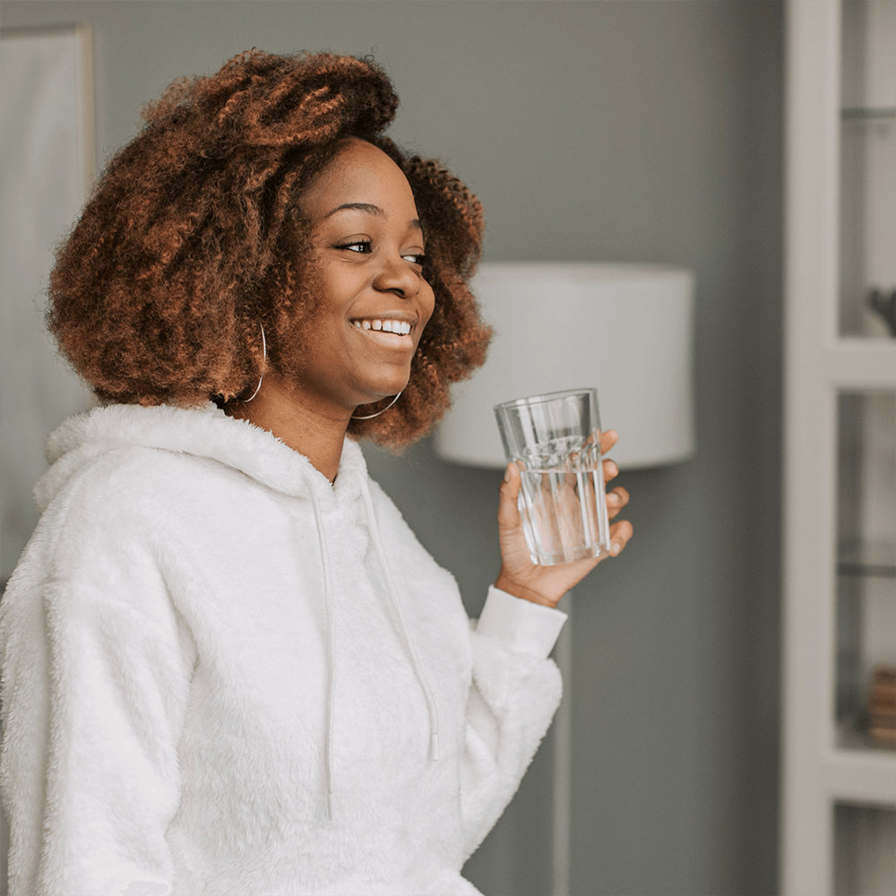 Jeune femme prenant un verre d'eau