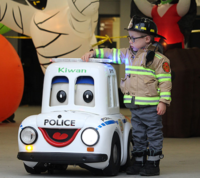 Kiwan, voiturette du Service de police, avec un petit garçon habillé en pompier